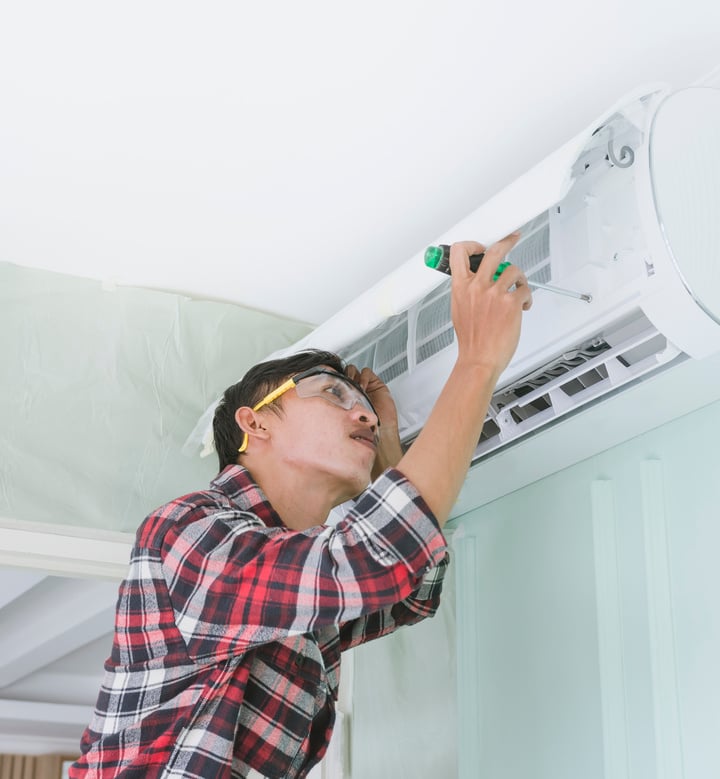 Handyman Repairing the Air Conditioning Unit