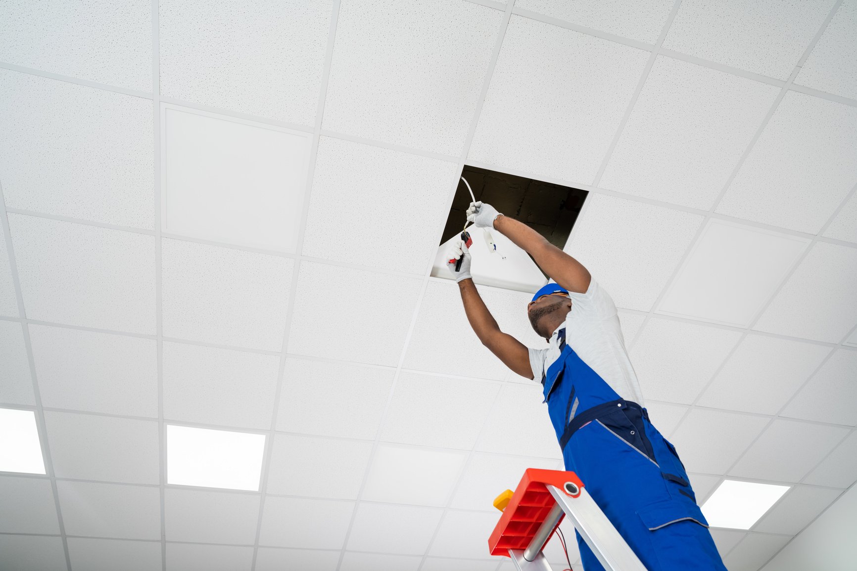 Electrician Installing Light On Ceiling